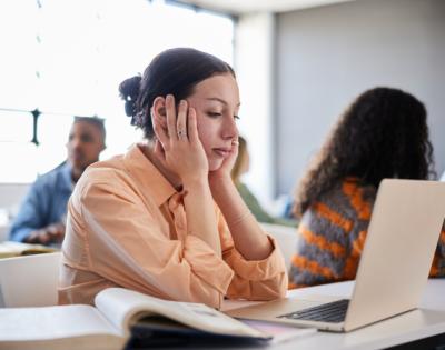 Woman sitting at computer desk looking stressed
